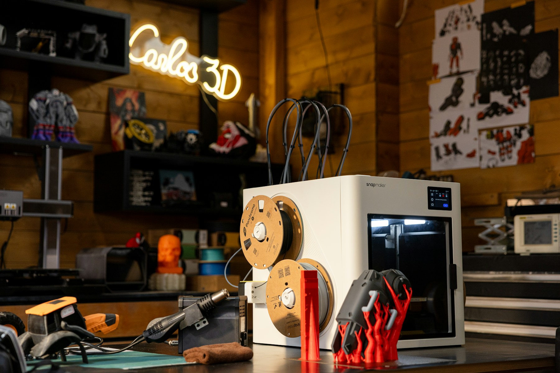 3D-принтер, катушки филамента и готовые детали в мастерской